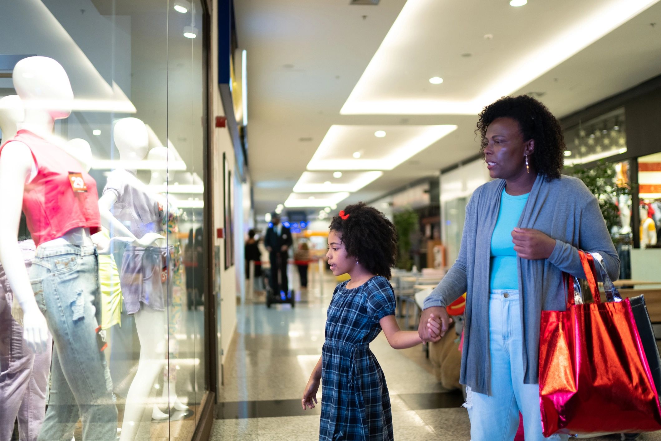 Mother and daughter looking at a store window at the mall