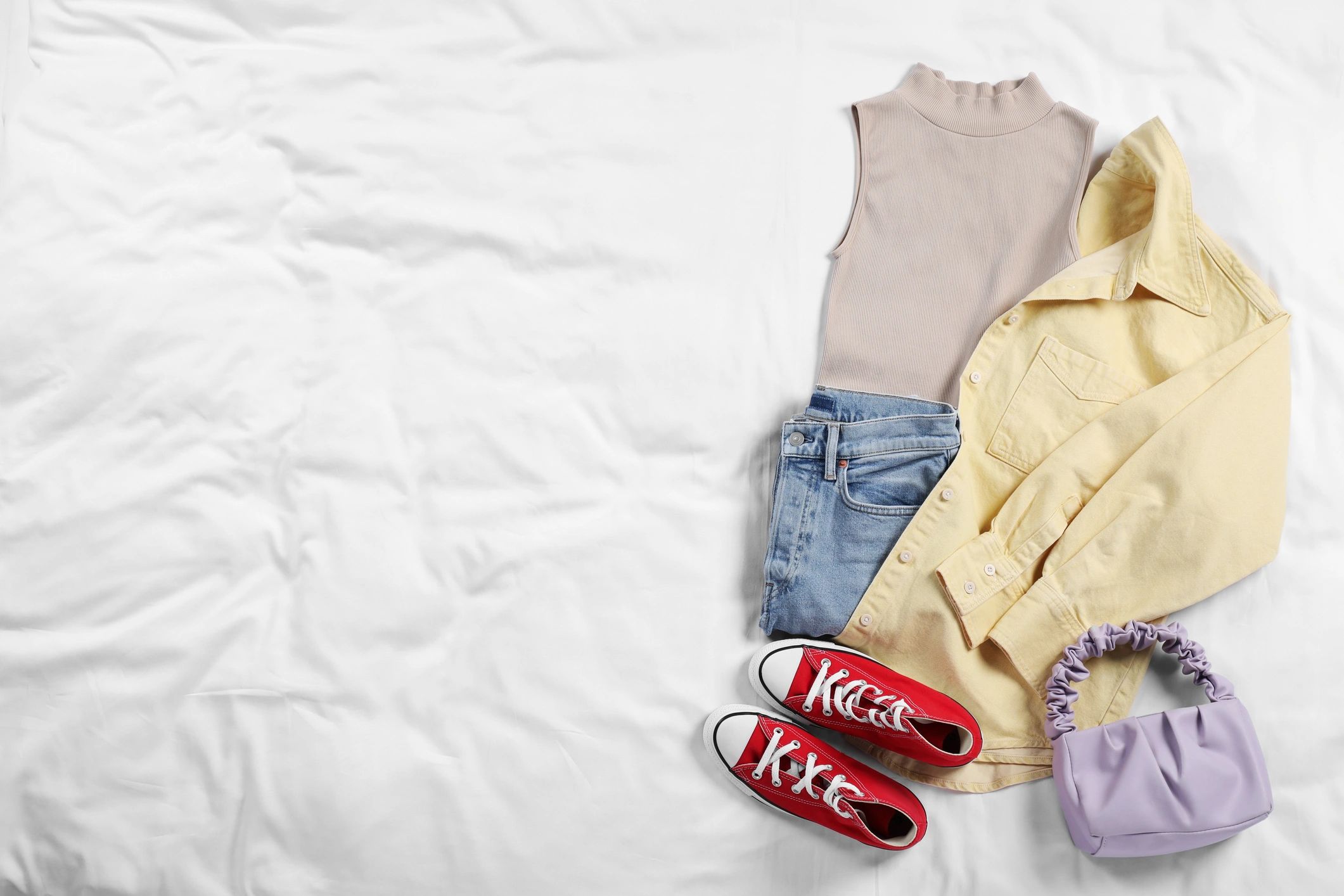 Stylish kids accessories and sneakers arranged on fabric