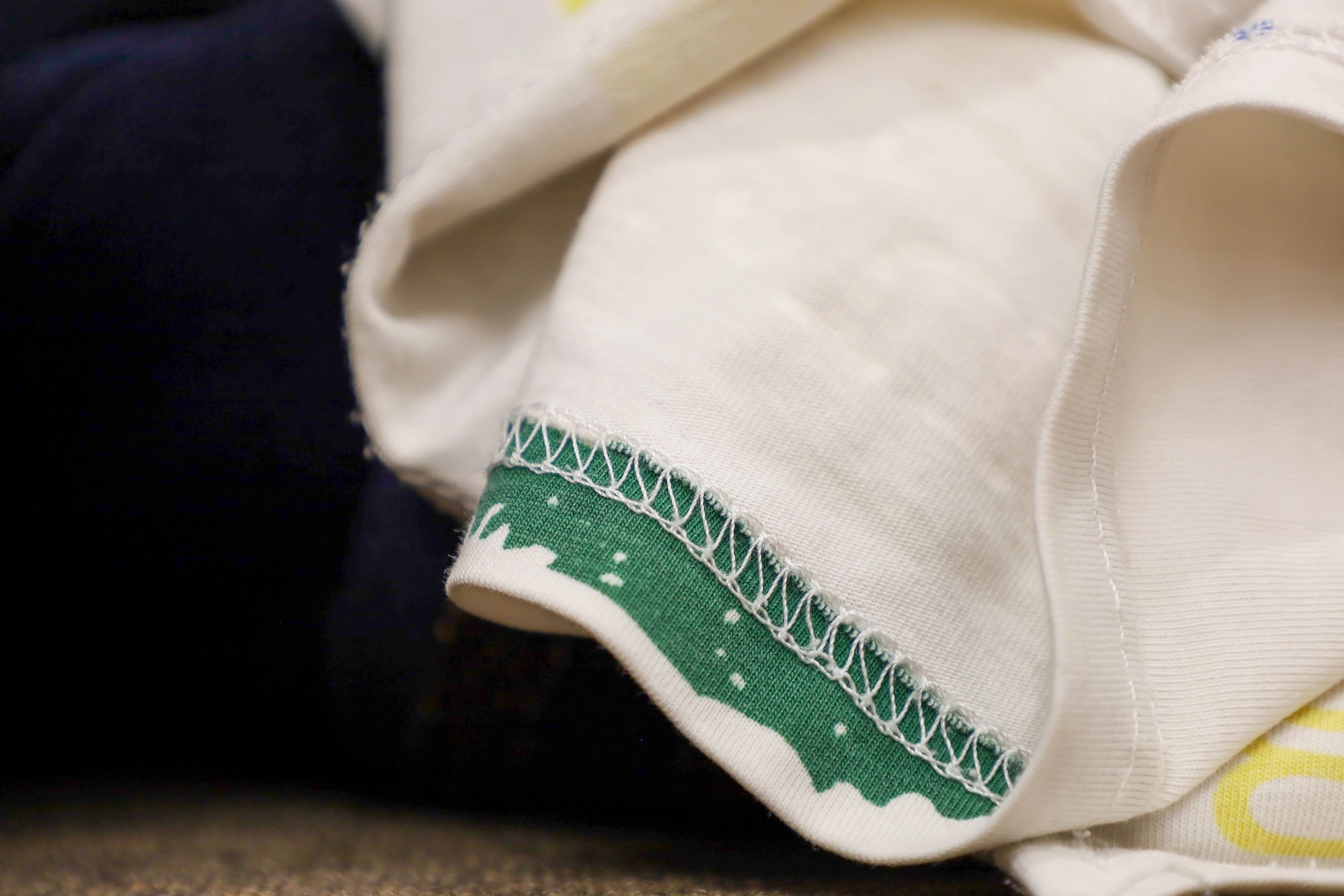 Folded children's clothing detail with decorative stitching